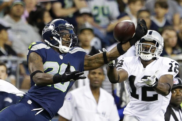 Seattle Seahawks' Walter Thurmond, left, makes a one-handed interception of a pass intended for Oakland Raiders' Jacoby Ford (12), right, in the first half of an NFL preseason football game on Thursday, Aug. 29, 2013, in Seattle. (AP Photo/Elaine Thompson)