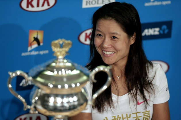 Li Na of China smiles beside the championship trophy, during a press conference,  after defeating Dominika Cibulkova of Slovakia in their women's singles final at the Australian Open tennis championship in Melbourne, Australia, Saturday, Jan. 25, 2014.(AP Photo/Rick Rycroft)
