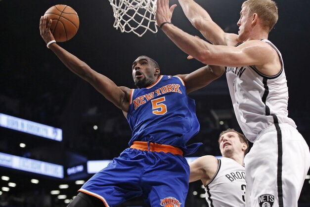 New York Knicks guard Tim Hardaway Jr. (5) goes up for a layup against the defense of Brooklyn Nets forward Mason Plumlee (1) in the second half of their NBA basketball game at the Barclays Center, Thursday, Dec. 5, 2013, in New York. Hardaway scored 12 points as the Knicks defeated the Nets 113-83. (AP Photo/Kathy Willens)