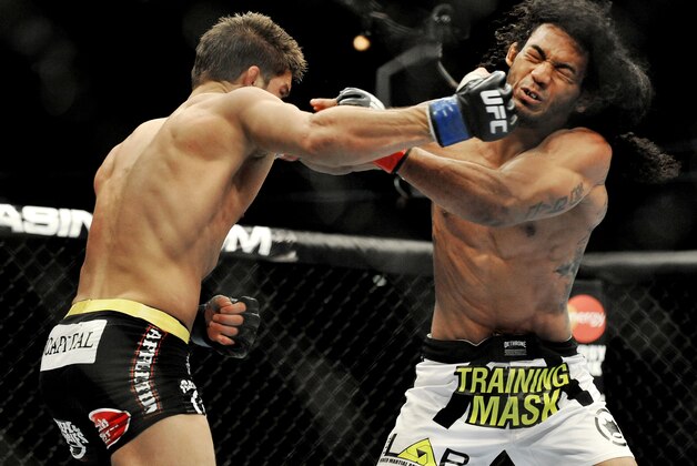 Josh Thomson, left, punches Benson Henderson right, during the main event of a UFC mixed martial arts event in Chicago, Saturday, Jan. 25, 2014. (AP Photo/Paul Beaty)