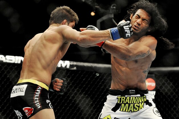 Josh Thomson, left, punches Benson Henderson right, during the main event of a UFC mixed martial arts event in Chicago, Saturday, Jan. 25, 2014. (AP Photo/Paul Beaty)