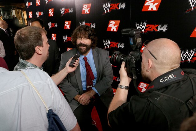 IMAGE DISTRIBUTED FOR 2K - WWE Hall of Famer Mick Foley talks with media at the WWE 2K14 press event, on Saturday, Aug. 17, 2013 in Los Angeles.  (Photo by Casey Rodgers/Invision for 2K/AP Images)