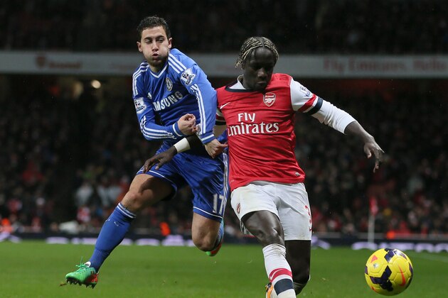 Chelsea's Eden Hazard, left, attempts to get past Arsenal's Bacary Sagna who shields the ball during their English Premier League soccer match between Arsenal and Chelsea at the Emirates stadium in London, Monday, Dec. 23, 2013. (AP Photo/Alastair Grant)