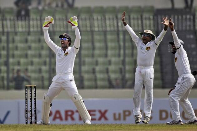 Sri Lanka’s wicketkeeper Dinesh Chandimal, left, and Rangana Herath, center, appeal successfully for a leg before wicket of Bangladesh's Marshall Ayub on the first day of their first test cricket match in Dhaka, Bangladesh, Monday, Jan. 27, 2014. (AP Photo/A.M. Ahad)