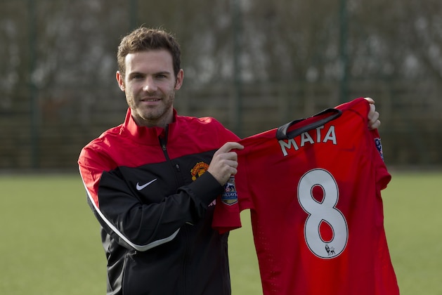 Manchester United's new signing Juan Mata displays his new shirt before a press conference at the team's Carrington training ground, Manchester, England, Monday, Jan. 27, 2014. With Manchester United in danger of missing out on the Champions League next season, Juan Mata's arrival at Old Trafford for a club record fee of 37.1 million pounds ($61.2 million) is certainly an emergency move. But it also marks the first step in the rebuilding process of England's most titled club. After a botched transfer campaign last summer that was followed by the club's lackluster first half of the season, United now looks determined to allow manager David Moyes the opportunity to build his own team.(AP Photo/Jon Super)