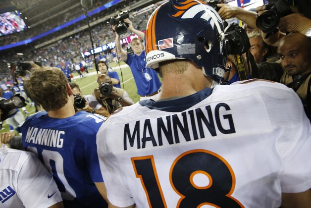 New York Giants' Eli Manning (10) shakes hands with his brother Denver Broncos quarterback Peyton Manning (18) during the second half of an NFL football game Sunday, Sept. 15, 2013, in East Rutherford, N.J. The Broncos won the game 41-23. (AP Photo/Kathy Willens)