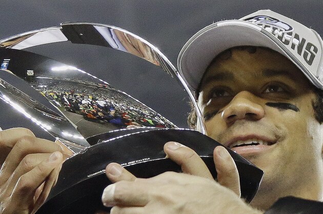Seattle Seahawks' Russell Wilson holds up the George Halas Trophy after the NFL football NFC Championship game against the San Francisco 49ers, Sunday, Jan. 19, 2014, in Seattle. The Seahawks won 23-17 to advance to Super Bowl XLVIII. (AP Photo/Matt Slocum)