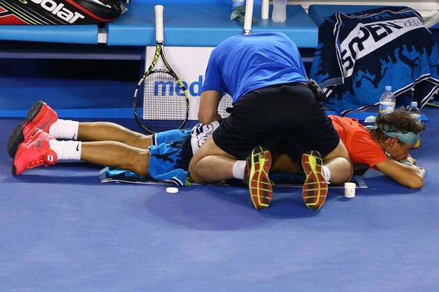 MELBOURNE, AUSTRALIA - JANUARY 26:  Rafael Nadal of Spain receives a back massage in his men's final match against Stanislas Wawrinka of Switzerland during day 14 of the 2014 Australian Open at Melbourne Park on January 26, 2014 in Melbourne, Australia.  (Photo by Robert Prezioso/Getty Images)
