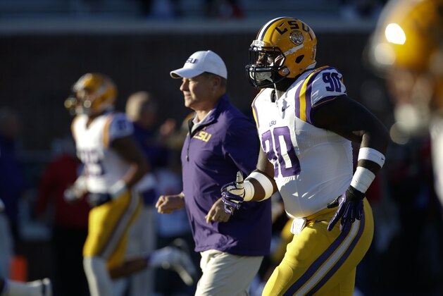 LSU defensive tackle Anthony Johnson (90) runs drills with teammates and football coach Les Miles during pregame drills before playing Mississippi in their NCAA college football game at Vaught-Hemingway Stadium in Oxford, Miss., Saturday, Oct. 19, 2013. Mississippi won 27-24. (AP Photo/Rogelio V. Solis)