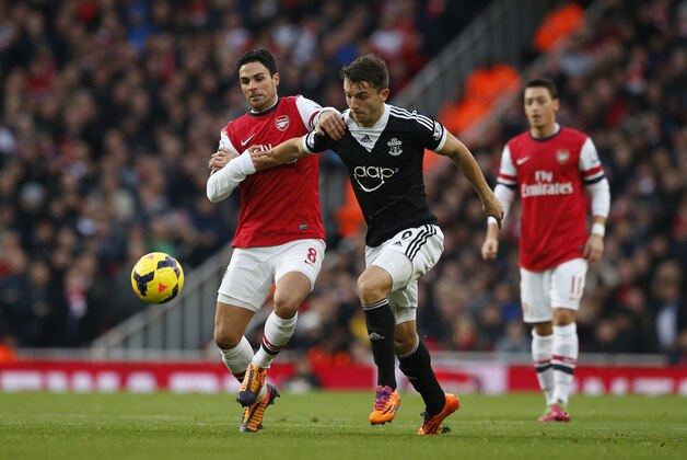 Arsenal's Mikel Arteta, left, competes for the ball with Southampton's Jay Rodriguez during the English Premier League soccer match between Arsenal and Southampton at the Emirates Stadium in London, Saturday, Nov. 23, 2013.  (AP Photo/Matt Dunham)