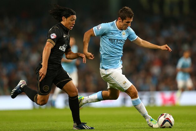 MANCHESTER, ENGLAND - SEPTEMBER 24:  Stevan Jovetic of Manchester City beats Roger Espinoza of Wigan Athletic during the Capital One Cup third round match between Manchester City and Wigan Athletic at Etihad Stadium on September 24, 2013 in Manchester, England.  (Photo by Alex Livesey/Getty Images)
