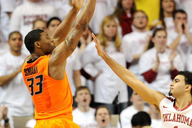 Oklahoma State guard Marcus Smart (33) takes a shot over Oklahoma guard Marcus Smart  (1) during the second half of an NCAA college basketball game in Norman, Okla., Monday, Jan. 27, 2014. Smart scored 22 points in the 76-88 loss to  rival Oklahoma. (AP Photo/Brody Schmidt)