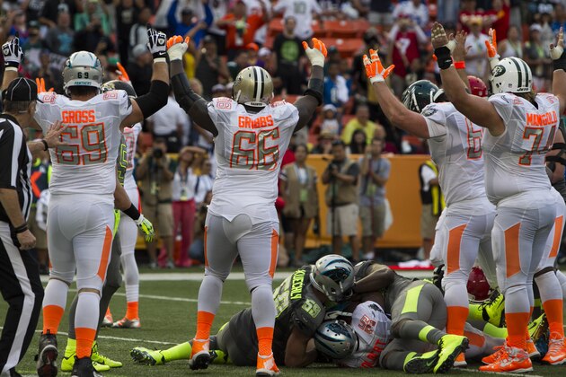 El equipo de Jerry Rice celebra después de que el fullback Mike Tolbert, de los Panthers de Carolina, anotó una conversión de dos puntos en el Pro Bowl, frente al conjunto de Deion Sanders, el domingo 26 de enero de 2014 (AP Foto/Marco García)