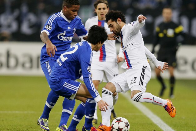 Schalke's Jefferson Farfan, left, Schalke's Atsuto Uchida, 2nd left, and Basel's Mohamed Salah challenge for the ball during the Champions League group E soccer match between FC Schalke 04 and FC Basel in Gelsenkirchen, Germany, Wednesday, Dec.11,2013. (AP Photo/Frank Augstein)
