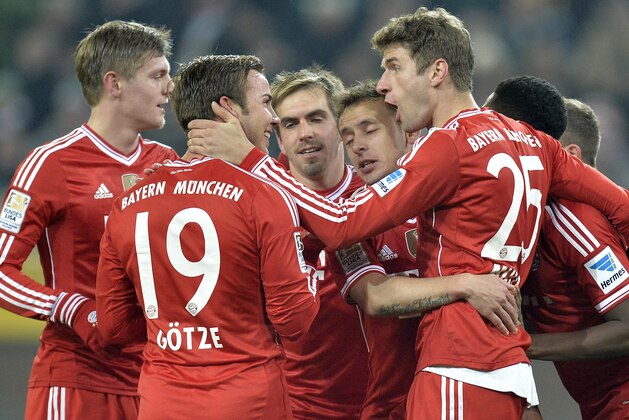 Bayern's Thomas Mueller, right, celebrates after scoring a penalty with Bayern's first scorer Mario Goetze, second from left,  during the German Bundesliga soccer match between Borussia Moenchengladbach and Bayern Munich in Moenchengladbach, Germany, Friday, Jan. 24, 2014. (AP Photo/Martin Meissner)