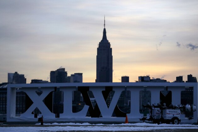 The Empire State Building, top, backdrops Roman numerals for the NFL Super Bowl XLVIII football game during sunrise at Pier A Park in Hoboken, N.J., Tuesday, Jan. 28, 2014. The Seattle Seahawks and the Denver Broncos are scheduled to play on Sunday, Feb. 2, 2014, at MetLife Stadium in East Rutherford, N.J. (AP Photo/Julio Cortez)
