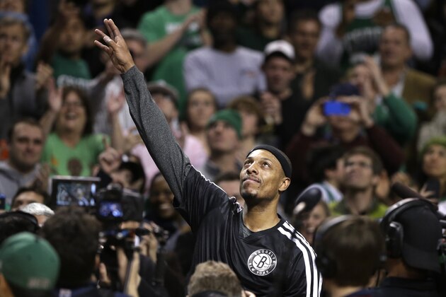 Brooklyn Nets forward Paul Pierce, center, formerly of the Boston Celtics, waves to the crowd during a tribute to him in an NBA basketball game against the Boston Celtics, Sunday, Jan. 26, 2014, in Boston. (AP Photo/Steven Senne)