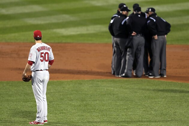 FILE - In this Oct. 23, 2013, file photo, St. Louis Cardinals starting pitcher Adam Wainwright watches as umpires discuss a ruling during the first inning of Game 1 of baseball's World Series against the Boston Red Sox in Boston. Major League Baseball announced Thursday, Jan. 16, 2014, that it will greatly expand instant replay to review close calls starting this season. Each manager will be allowed to challenge at least one call per game. If he's right, he gets another challenge.  After the seventh inning, a crew chief can request a review on his own. (AP Photo/Charles Krupa, File)