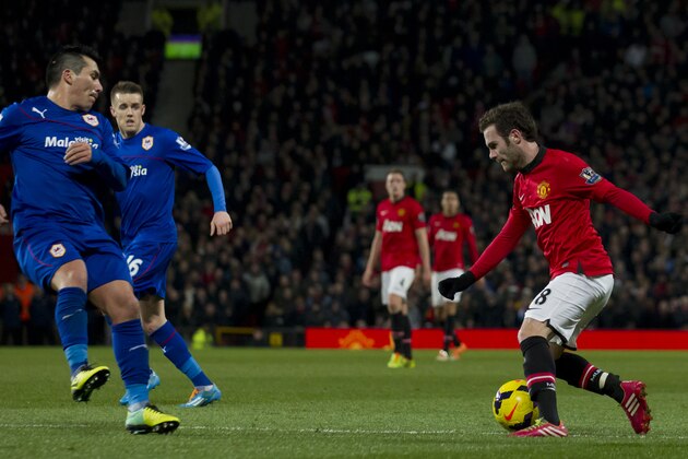 Manchester United's Juan Mata, right, keeps the ball from Cardiff City's Gary Medel, left, and Craig Noone, second left, during their English Premier League soccer match at Old Trafford Stadium, Manchester, England, Tuesday Jan. 28, 2014. (AP Photo/Jon Super)