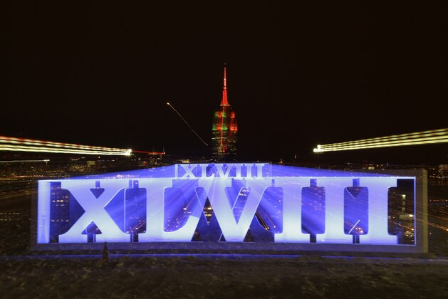 In this photograph taken while zooming out the lens during a long exposure, the Empire State Building, top, backdrops roman numerals for the NFL Super Bowl XLVIII football game at Pier A Park in Hoboken, N.J., Tuesday, Jan. 28, 2014. The Seattle Seahawks and the Denver Broncos are scheduled to play on Sunday, Feb. 2, 2014, at MetLife Stadium in East Rutherford, N.J. (AP Photo/Julio Cortez)