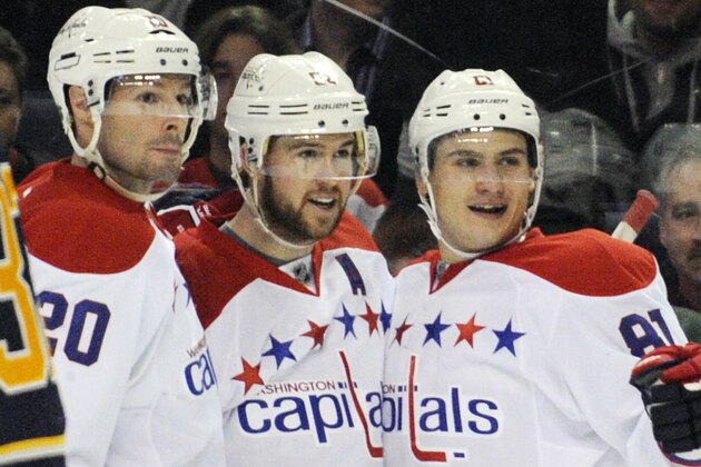 Buffalo Sabres' John Scott (32) reacts as he skates by a celebration of Washington Capitals' Troy Brouwer, left, Mike Green, center, and Dmitry Orlov, right, after a goal by Mike Green during the second period of an NHL hockey game in Buffalo, N.Y., Tuesday, Jan. 28, 2014. Washington won 5-4 in overtime. (AP Photo/Gary Wiepert)