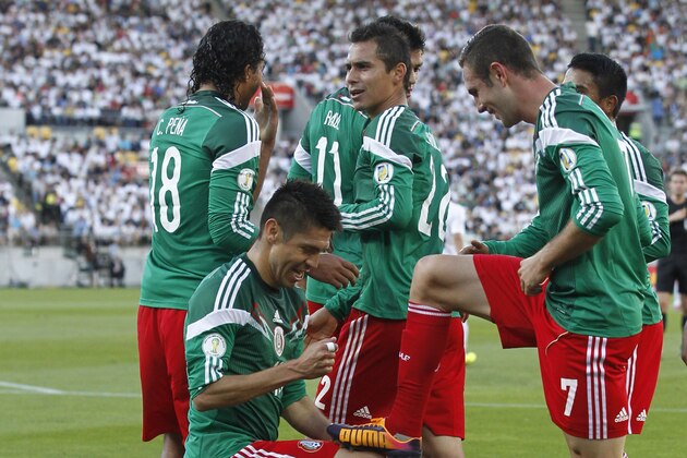 Mexico's Oribe Peralta, left in foreground, celebrates after scoring a goal against New Zealand in their World Cup qualifying soccer match at Westpac Stadium in Wellington, New Zealand, Wednesday, Nov. 20, 2013. (AP Photo/SNPA, John Cowpland) NEW ZEALAND OUT