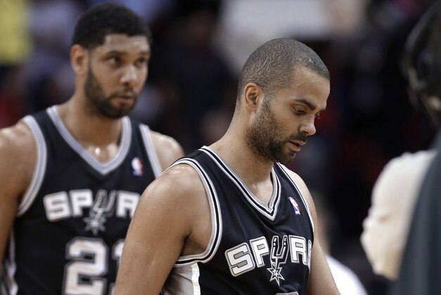 San Antonio Spurs Tony Parker (9) and Tim Duncan (21) head to the bench for a timeout near the end of an NBA basketball game against the Houston Rockets on Tuesday, Jan. 28, 2014, in Houston. The Rockets won 97-90. (AP Photo/Pat Sullivan)