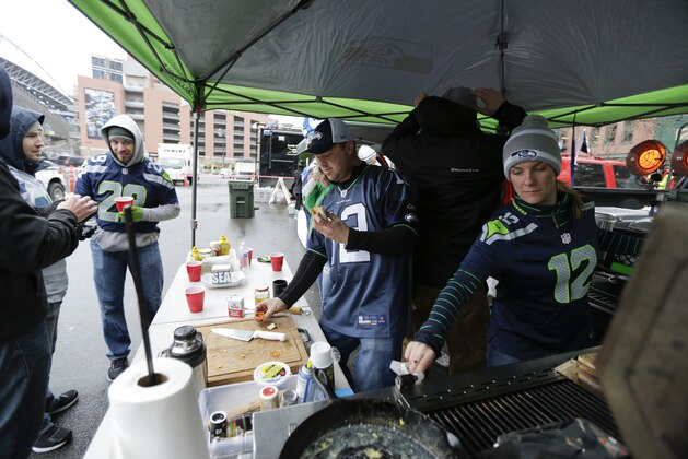 Seattle Seahawks fans John and Heather Potts prepare food as they tailgate outside of CenturyLink Field before an NFC divisional playoff NFL football game between the Seattle Seahawks and the New Orleans Saints in Seattle, Saturday, Jan. 11, 2014. (AP Photo/Ted S. Warren)