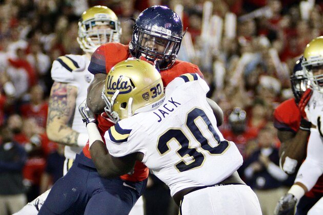 Arizona's Ka'Deem Carey, behind, drives to the endzone for a touchdown while UCLA's Myles Jack (30) holds on in the first half of an NCAA college football game, Saturday, Nov. 9, 2013 in Tucson, Ariz.  (AP Photo/Wily Low)