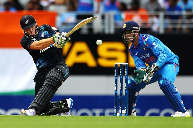AUCKLAND, NEW ZEALAND - JANUARY 25: Martin Guptill of New Zealand bats as MS Dhoni of India looks on during the One Day International match between New Zealand and India at Eden Park on January 25, 2014 in Auckland, New Zealand.  (Photo by Anthony Au-Yeung/Getty Images)