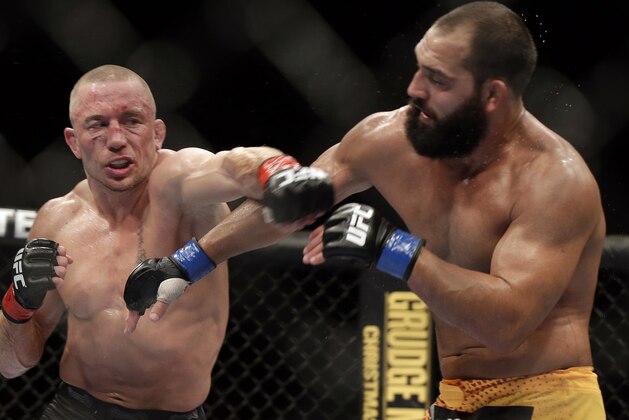 Johny Hendricks, right, exchanges punches with Georges St. Pierre, of Canada, during a UFC 167 mixed martial arts championship welterweight bout on Saturday, Nov. 16, 2013, in Las Vegas. St. Pierre won by split decision. (AP Photo/Isaac Brekken)