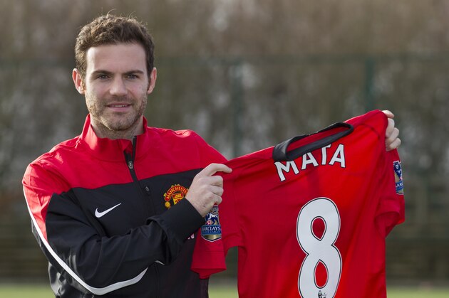 Manchester United's new signing Juan Mata displays his new shirt before a press conference at the team's Carrington training ground, Manchester, England, Monday, Jan. 27, 2014. With Manchester United in danger of missing out on the Champions League next season, Juan Mata's arrival at Old Trafford for a club record fee of 37.1 million pounds ($61.2 million) is certainly an emergency move. But it also marks the first step in the rebuilding process of England's most titled club. After a botched transfer campaign last summer that was followed by the club's lackluster first half of the season, United now looks determined to allow manager David Moyes the opportunity to build his own team.(AP Photo/Jon Super)