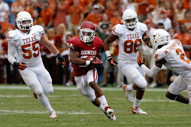DALLAS, TX - OCTOBER 13:  Brennan Clay #24 of the Oklahoma Sooners carries the ball against Dalton Santos #55 of the Texas Longhorns, Cedric Reed #88 of the Texas Longhorns and Mykkele Thompson #2 of the Texas Longhorns at Cotton Bowl on October 13, 2012 in Dallas, Texas. The Oklahoma Sooners beat the Texas Longhorns 63-21. (Photo by Tom Pennington/Getty Images)
