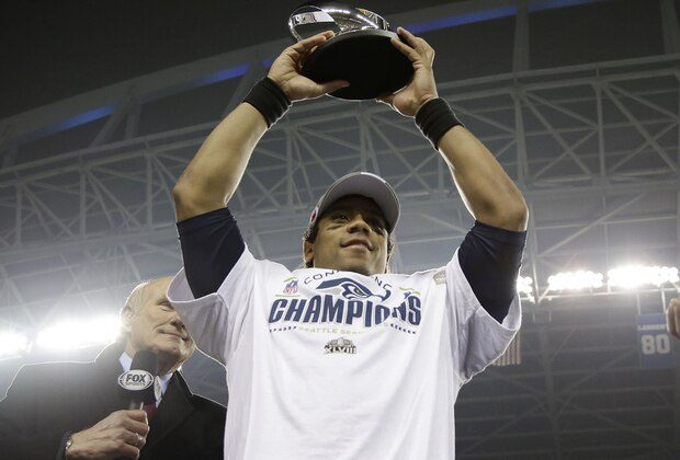 Seattle Seahawks' Russell Wilson holds up George Halas Trophy after the NFL football NFC Championship game against the San Francisco 49ers Sunday, Jan. 19, 2014, in Seattle. The Seahawks won 23-17 to advance to Super Bowl XLVIII. (AP Photo/Matt Slocum)