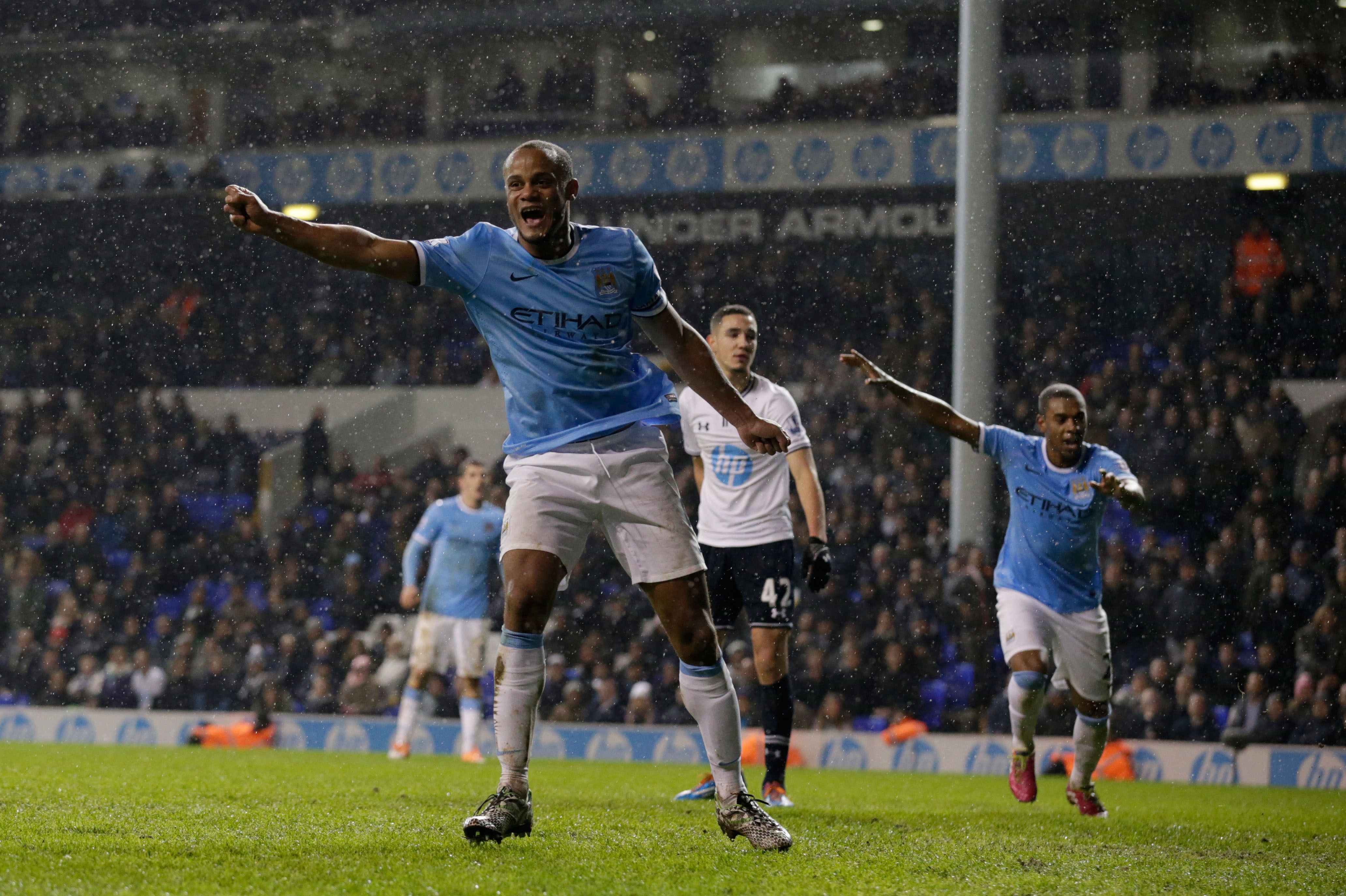 Manchester City's Vincent Kompany, left, celebrates scoring his side's fifth goal during the English Premier League soccer match between Tottenham Hotspur and Manchester City at White Hart Lane stadium in London, Wednesday, Jan. 29, 2014.  (AP Photo/Matt Dunham)
