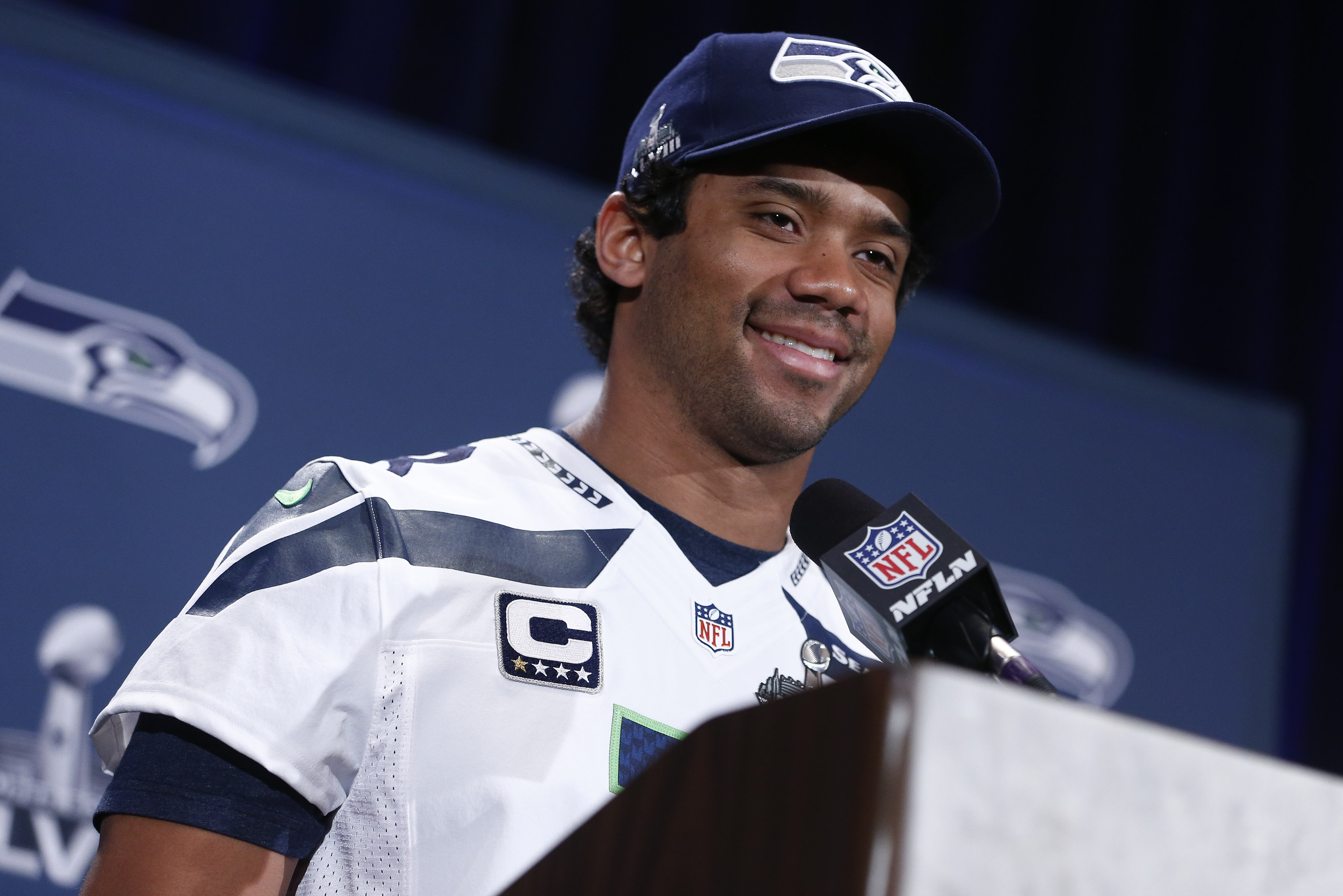 JERSEY CITY, NJ - JANUARY 29:   Russell Wilson #3 of the Seattle Seahawks speaks to the media during an availability January 29, 2014 in Jersey City, New Jersey. The Denver Broncos and Seattle Seahawks will meet at Super Bowl XLVIII at Metlife Stadium on February 2, 2014. (Photo by Jeff Zelevansky/Getty Images)