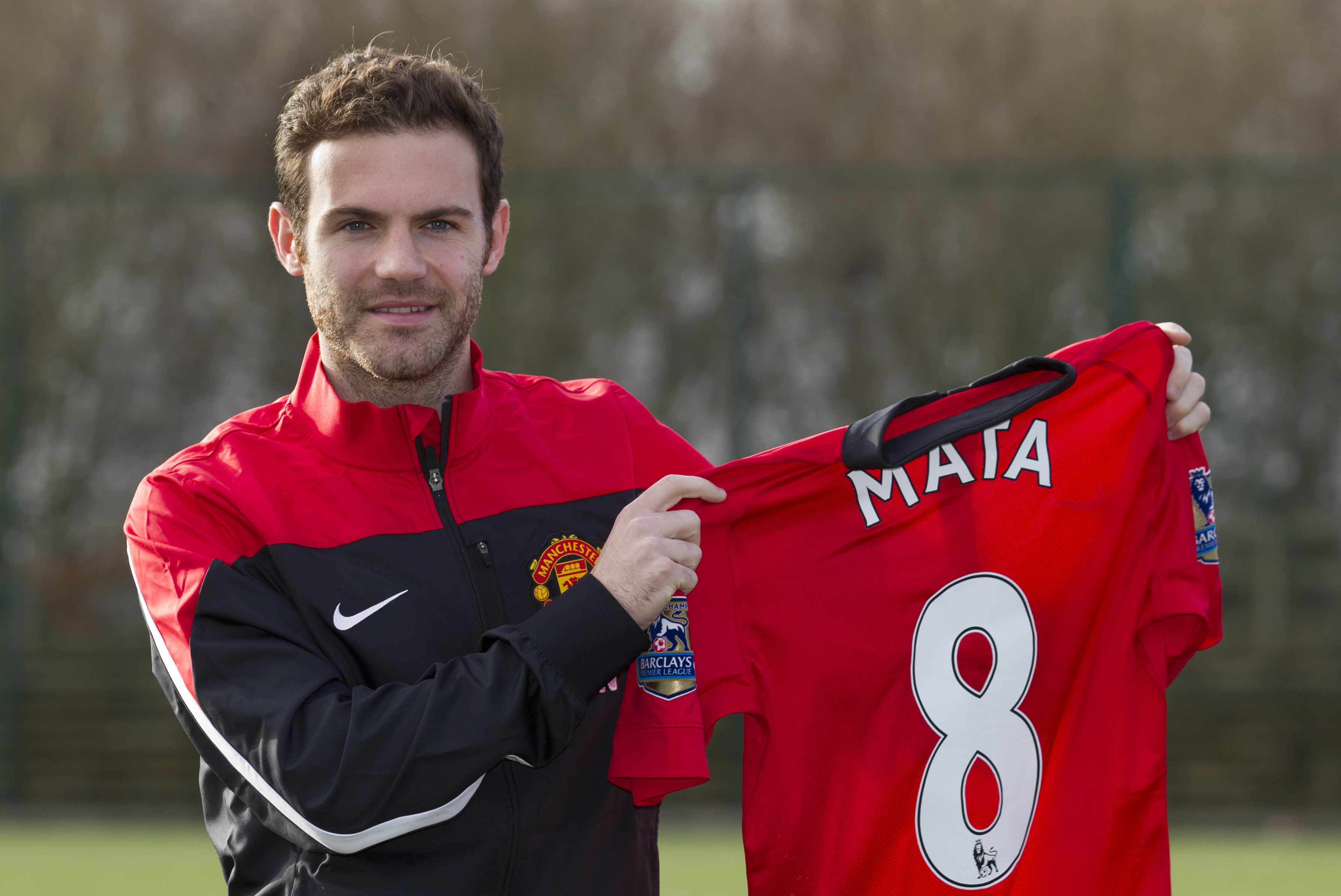 Manchester United's new signing Juan Mata displays his new shirt before a press conference at the team's Carrington training ground, Manchester, England, Monday, Jan. 27, 2014. With Manchester United in danger of missing out on the Champions League next season, Juan Mata's arrival at Old Trafford for a club record fee of 37.1 million pounds ($61.2 million) is certainly an emergency move. But it also marks the first step in the rebuilding process of England's most titled club. After a botched transfer campaign last summer that was followed by the club's lackluster first half of the season, United now looks determined to allow manager David Moyes the opportunity to build his own team.(AP Photo/Jon Super)