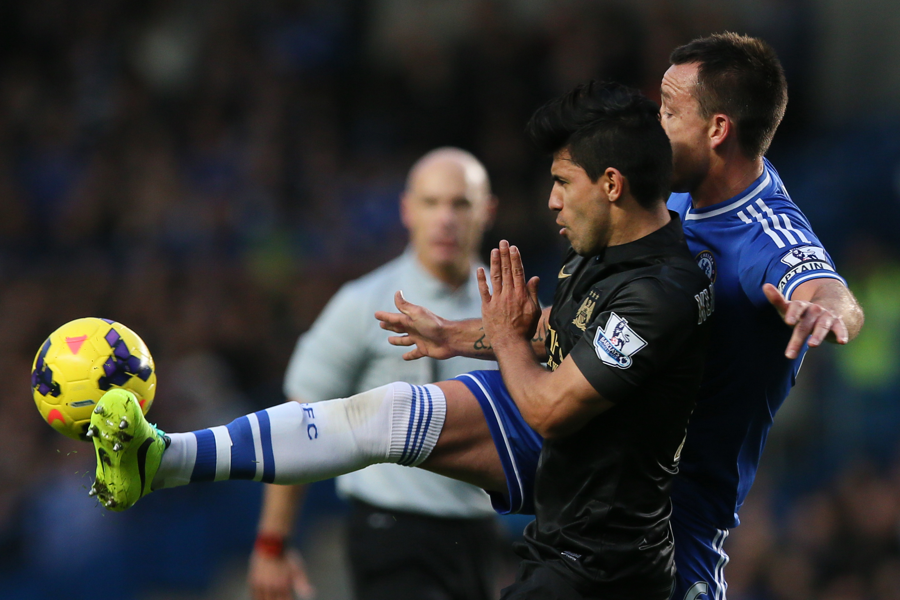 Chelsea's John Terry, right, puts his foot up to block a pass to Manchester City's Sergio Aguero, left, during their English Premier League soccer match between Chelsea and Manchester City at Stamford Bridge stadium in London, Sunday, Oct.  27, 2013. (AP Photo/Alastair Grant)