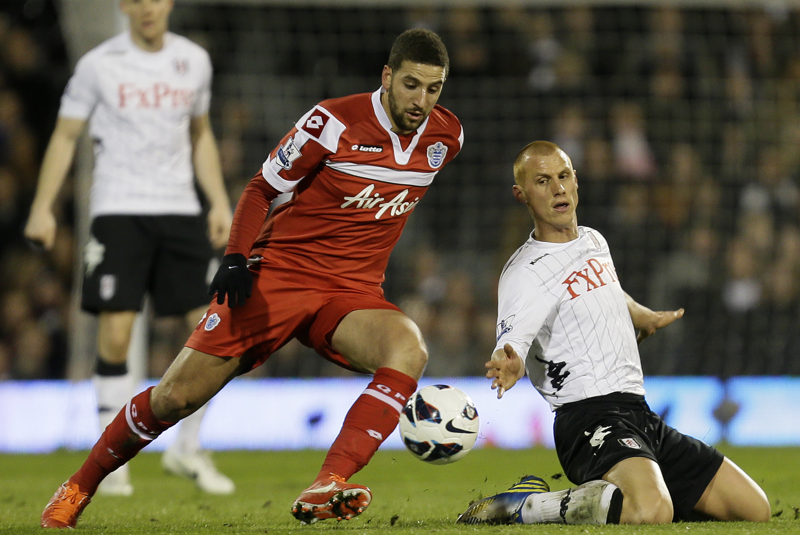 Queens Park Rangers' Adel Taarabt, left, takes the ball past Fulham's Steve Sidwell during the English Premier League soccer match between Fulham and QPR at Fulham's Craven Cottage stadium in London, Monday, April 1, 2013. (AP Photo/Alastair Grant)
