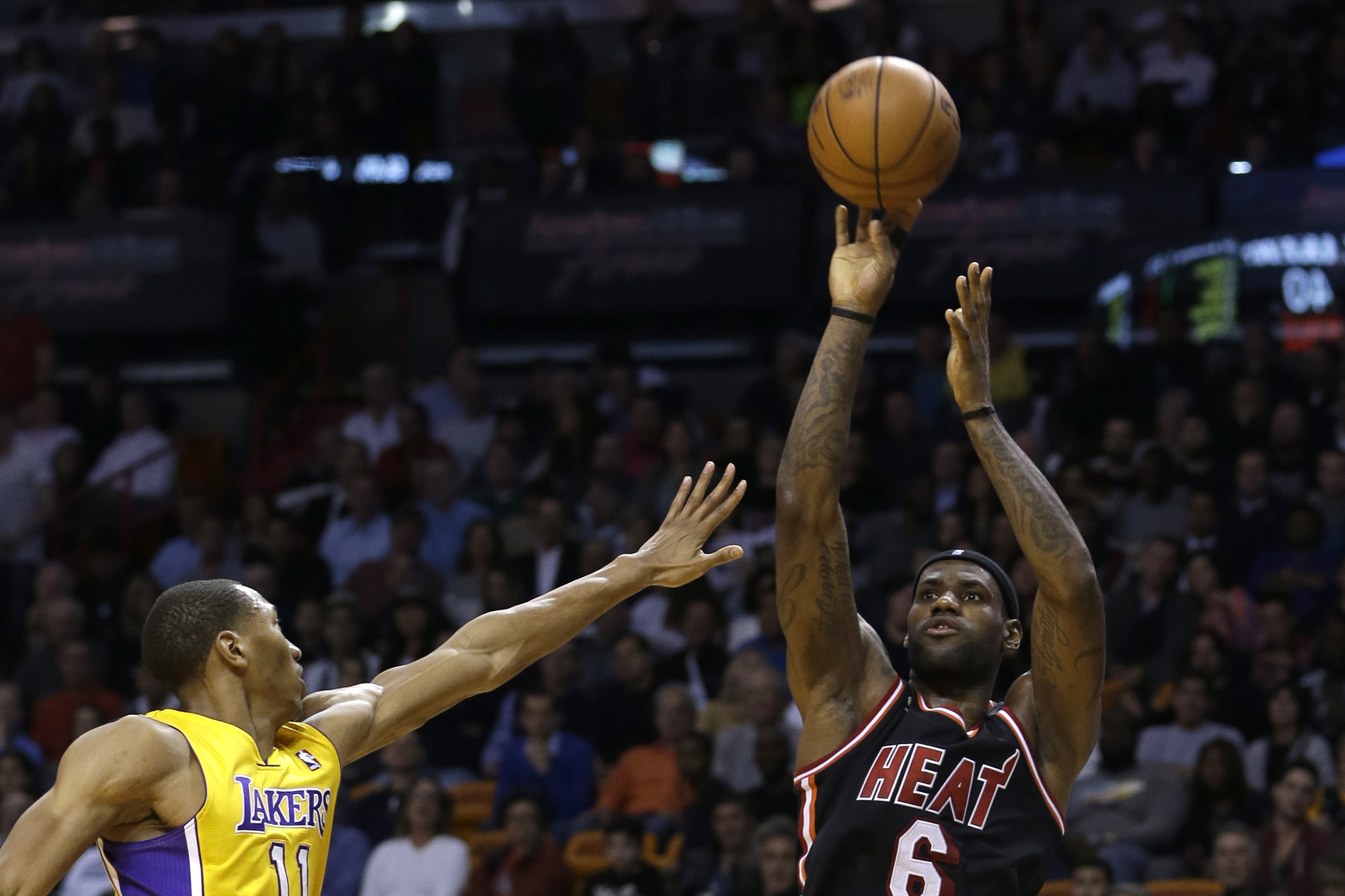 Miami Heat forward LeBron James (6) shoots for three points over  Los Angeles Lakers forward Wesley Johnson (11)  during the second quarter of an NBA basketball game in Miami, Thursday, Jan. 23, 2014. The Heat won 109-102.  (AP Photo/Alan Diaz)