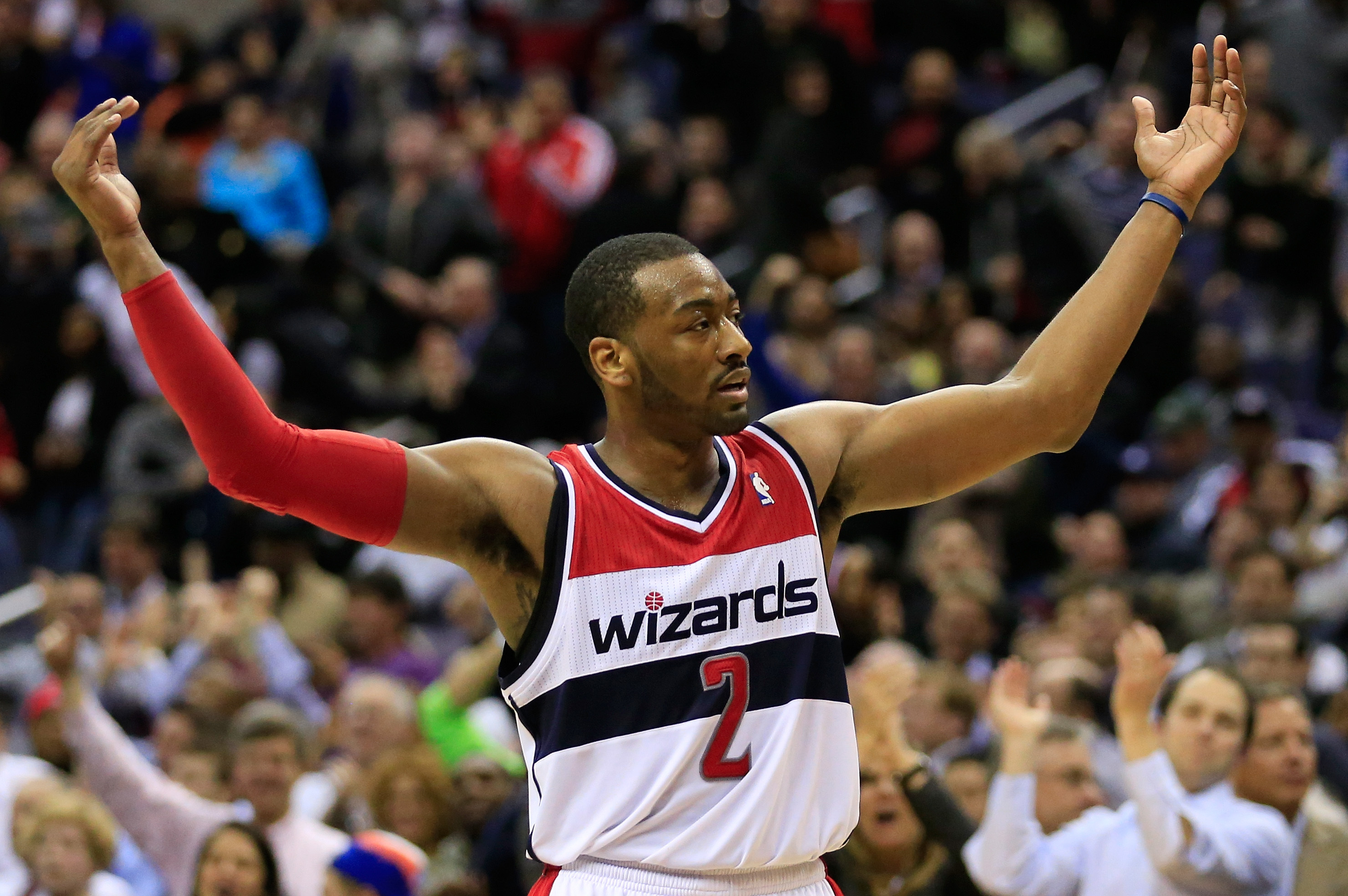 WASHINGTON, DC - JANUARY 15:  John Wall #2 of the Washington Wizards celebrates during the closing moments of the Wizards 114-97 win over the Miami Heat at Verizon Center on January 15, 2014 in Washington, DC. NOTE TO USER: User expressly acknowledges and agrees that, by downloading and or using this photograph, User is consenting to the terms and conditions of the Getty Images License Agreement.  (Photo by Rob Carr/Getty Images)