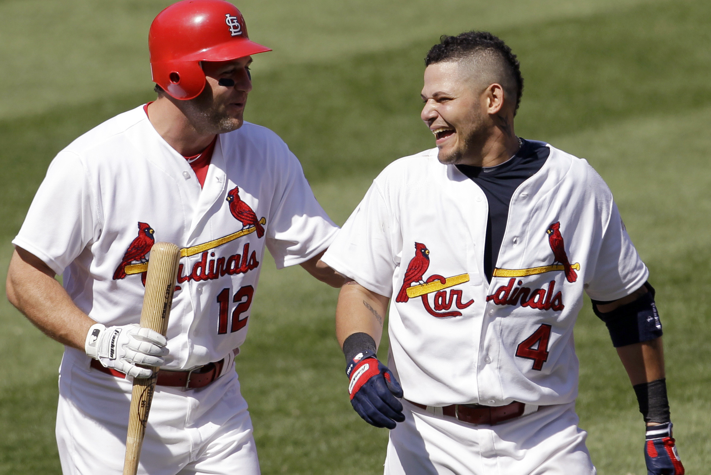 St. Louis Cardinals' Yadier Molina, right, laughs as he is congratulated by Lance Berkman after hitting a ninth-inning single to give the Cardinals a 7-6 win over the Chicago Cubs in a baseball game Tuesday, May 15, 2012, in St. Louis. (AP Photo/Jeff Roberson)