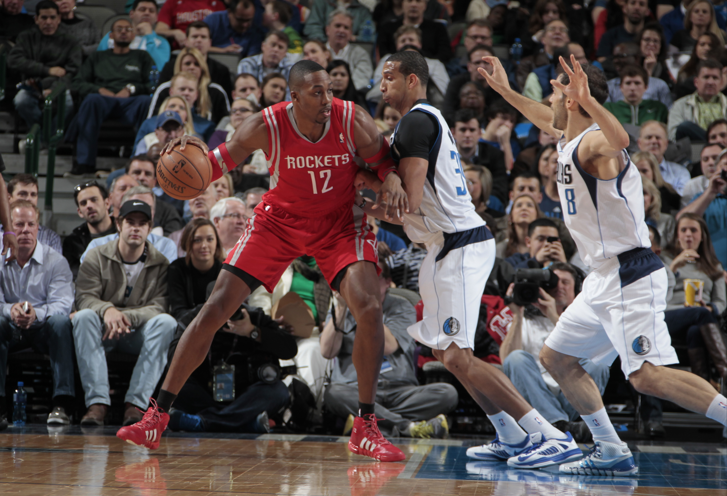DALLAS, TX - JANUARY 29: Dwight Howard #12 of the Houston Rockets controls the ball against Brandan Wright #34 and the Dallas Mavericks on January 29, 2014 at the American Airlines Center in Dallas, Texas. NOTE TO USER: User expressly acknowledges and agrees that, by downloading and or using this photograph, User is consenting to the terms and conditions of the Getty Images License Agreement. Mandatory Copyright Notice: Copyright 2014 NBAE (Photo by Danny Bollinger/NBAE via Getty Images)