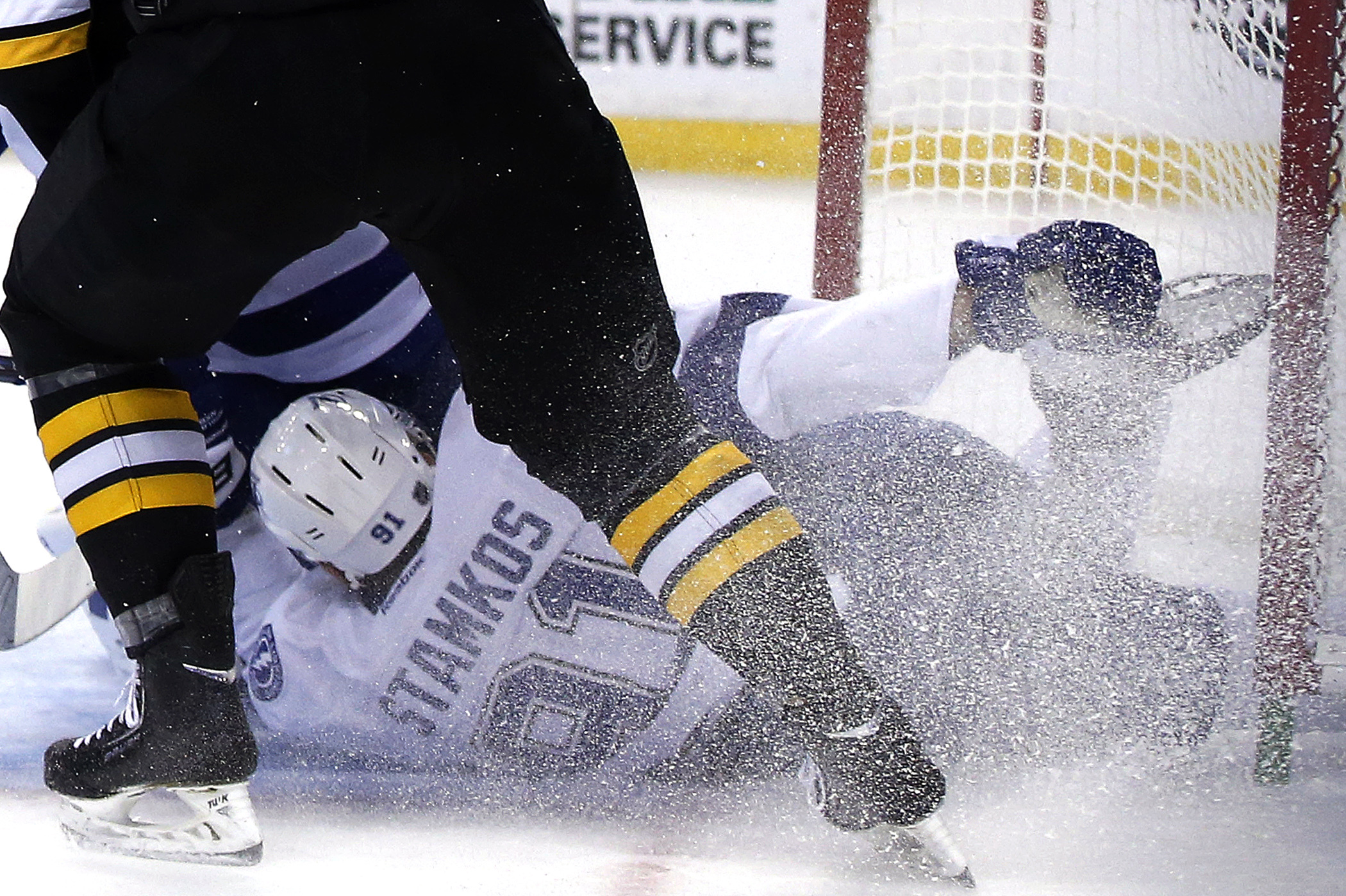 Tampa Bay Lightning center Steven Stamkos holds his skate after banging into the goalpost defending against Boston Bruins defenseman Dougie Hamilton, above, during the second period of an NHL hockey game in Boston Monday, Nov. 11, 2013. Stamkos was taken off the ice on a stretcher after the play. (AP Photo/Elise Amendola)