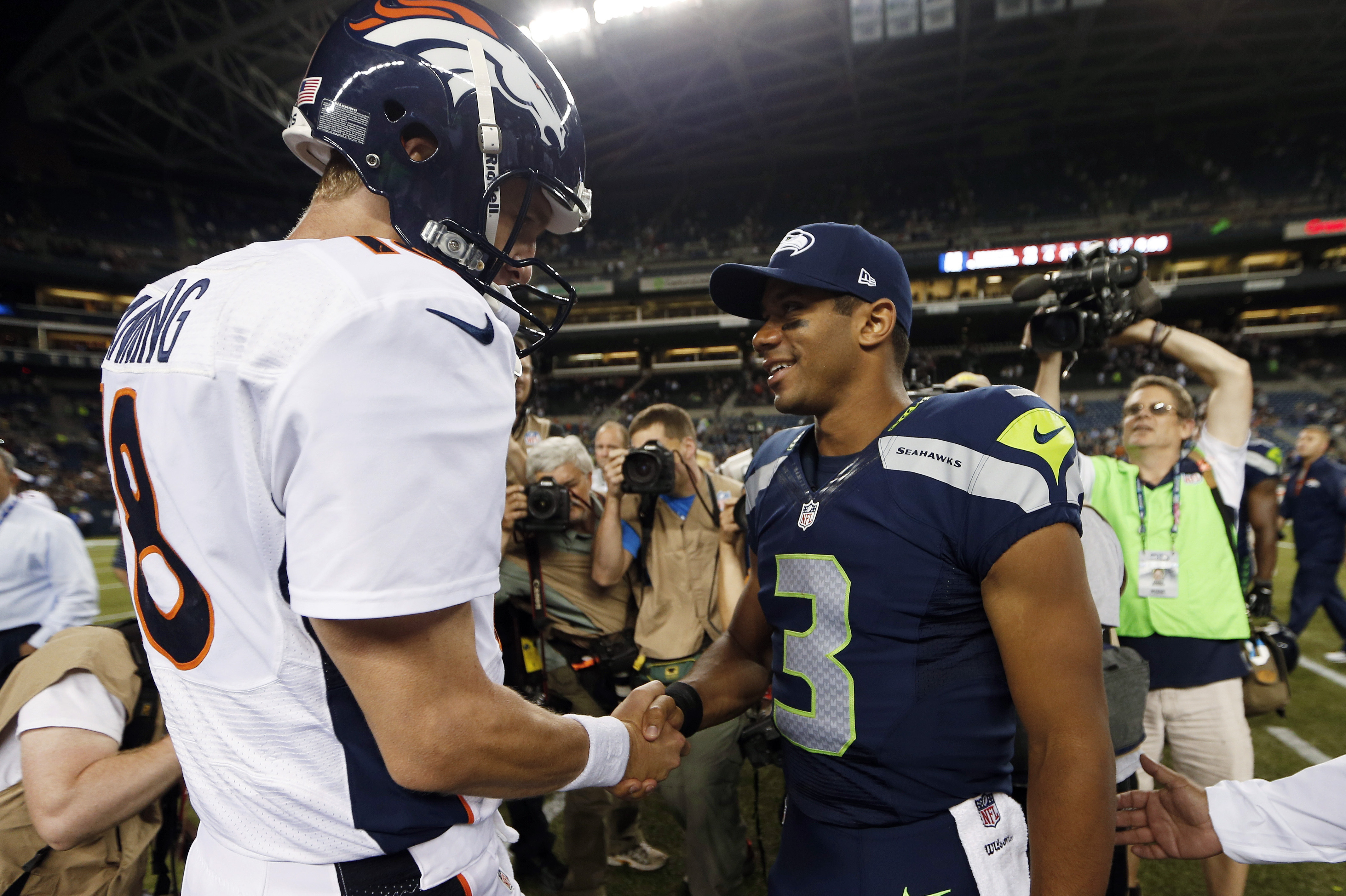 ADVANCE FOR WEEKEND EDITIONS, JAN. 25-26 - FILE - In this Aug. 17, 2013, file photo, Seattle Seahawks quarterback Russell Wilson (3) shakes hands with Denver Broncos quarterback Peyton Manning, left, after the Seahawks beat the Broncos 40-10 in preseason NFL football game  in Seattle. The two teams are slated to meet in Super Bowl XLVIII on Sunday, Feb. 2, 2014, in East Rutherford, N.J. (AP Photo/John Froschauer, File)