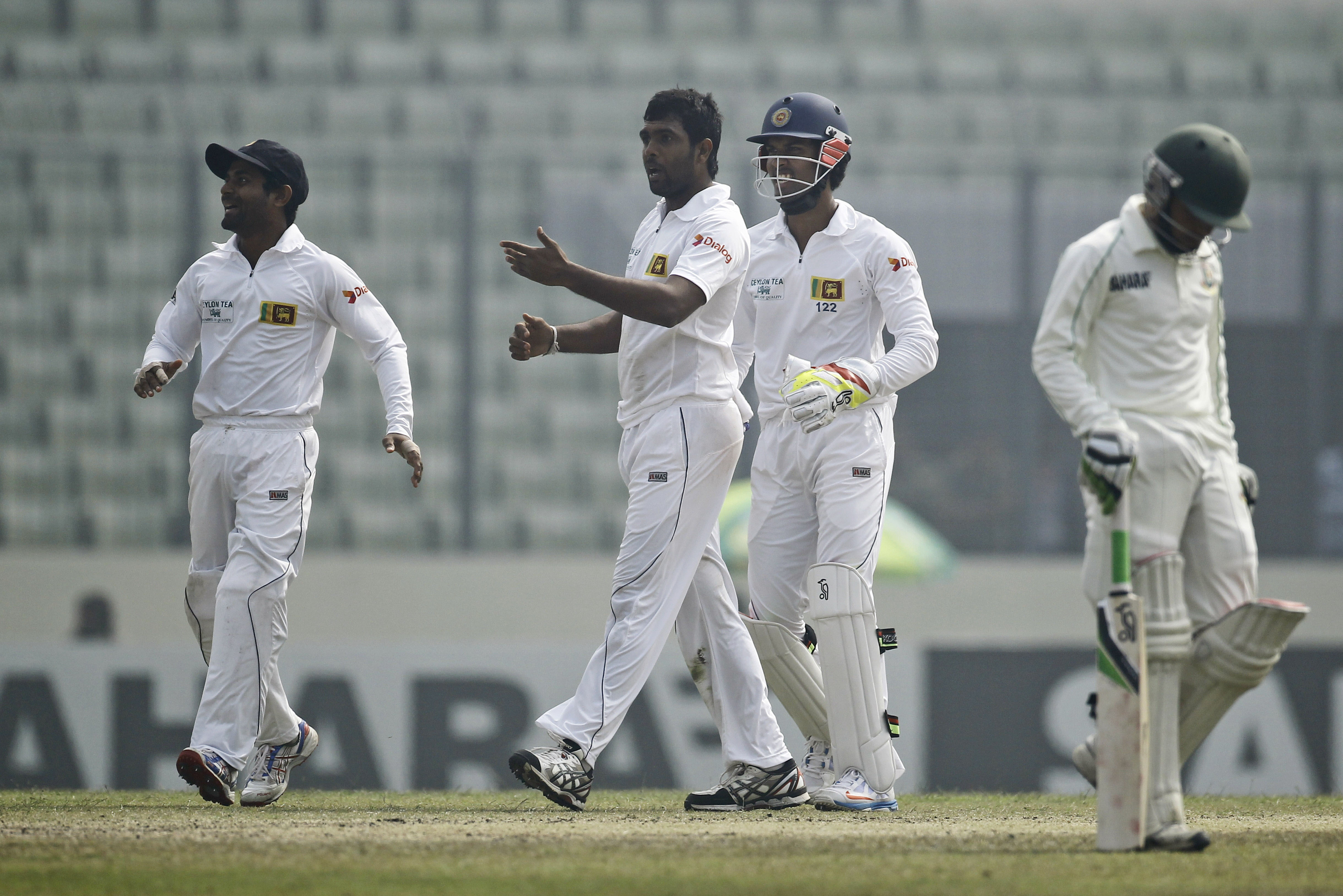Sri Lanka’s Dilruwan Perera, second left, celebrates the wicket of Bangladesh's Mominul Haque, right, on the fourth day of their first test cricket match in Dhaka, Bangladesh, Thursday, Jan. 30, 2014. (AP Photo/A.M. Ahad)