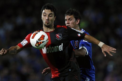 Chile's Universidad de Chile's Igor Lichnovsky, back, fights for a ball with Argentina's Newells' Old Boys's Ignacio Scocco during a Copa Libertadores soccer match in Santiago, Chile, Tuesday, March 12, 2013. (AP Photo/Luis Hidalgo)