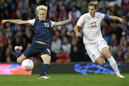 United States' Megan Rapinoe, left, prepares to kick the ball against Canada's Christine Sinclair, right, during their semifinal women's soccer match at the 2012 London Summer Olympics, in Manchester, England, Monday, Aug. 6, 2012. (AP Photo/Hussein Malla)