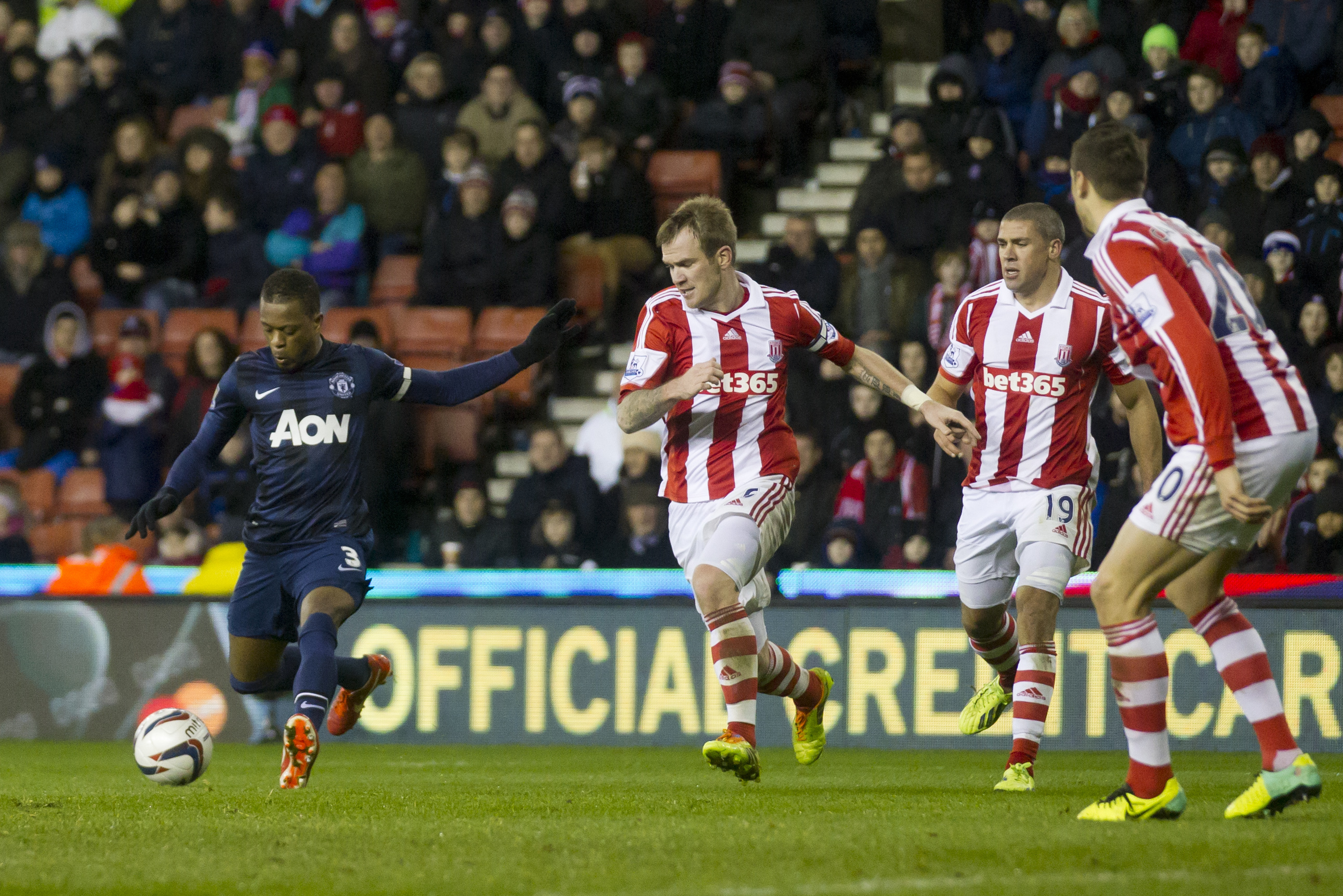 Manchester United's Patrice Evra, left, scores against Stoke during their English League Cup quarter-final soccer match at the Britannia Stadium, Stoke, England, Wednesday Dec. 18, 2013. (AP Photo/Jon Super)