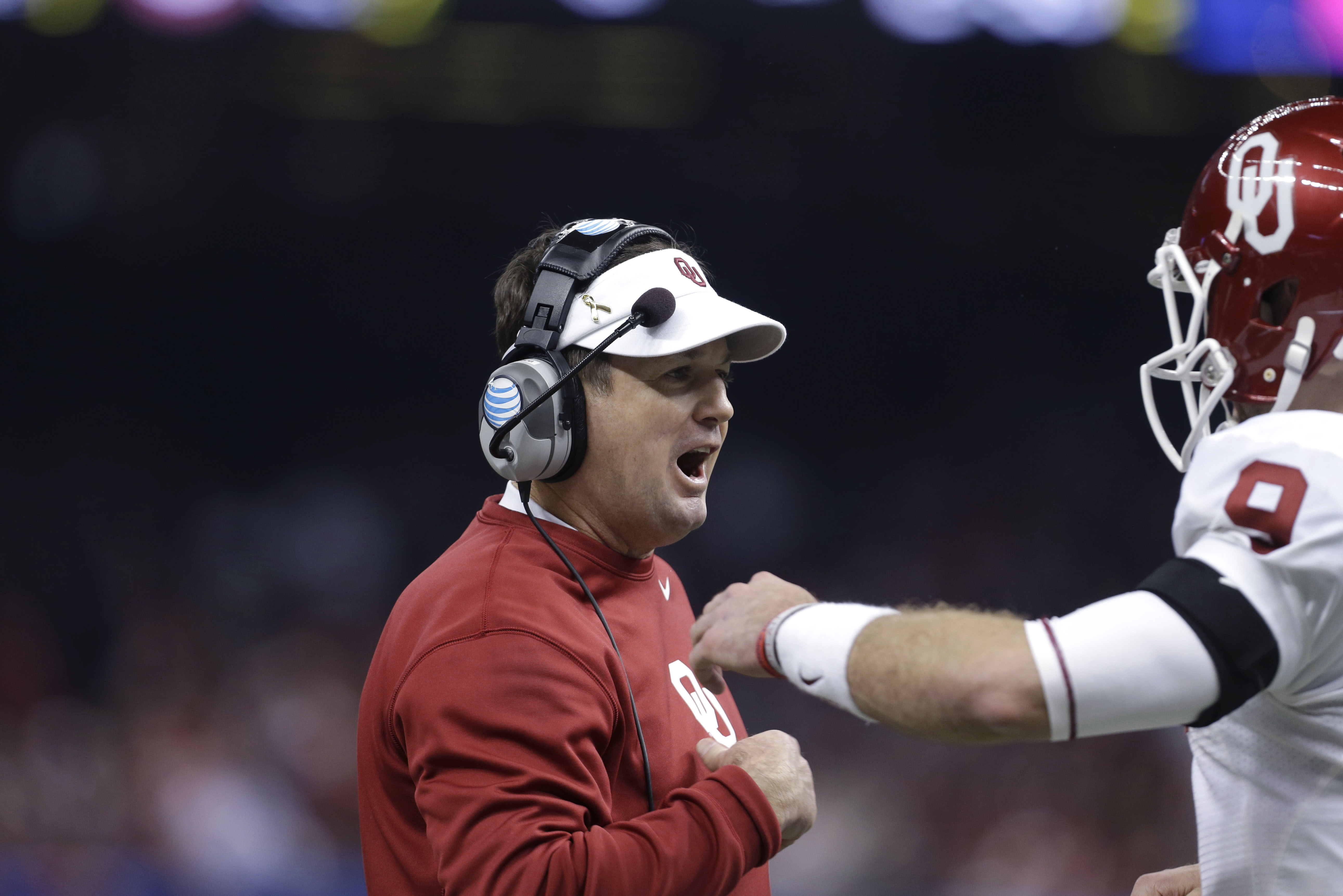 Oklahoma head coach Bob Stoops reaches out to quarterback Trevor Knight (9) in the first half of the NCAA college football Sugar Bowl in New Orleans, Thursday, Jan. 2, 2014. (AP Photo/Rusty Costanza)